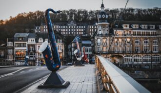 Le célèbre pont de Dinant orné de ses saxophones géants colorés en hommage à Adolphe Sax, avec une vue imprenable sur la Meuse et la Citadelle.