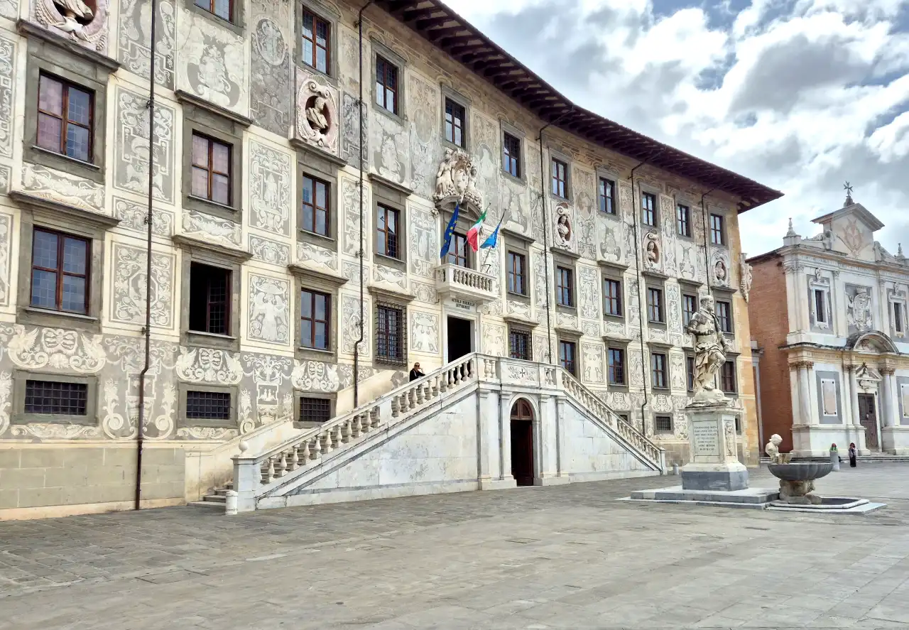 Façade du Palazzo della Carovana ornée de sgraffites sur la Piazza dei Cavalieri à Pise, montrant l'escalier à double rampe et la statue de Cosme Ier.