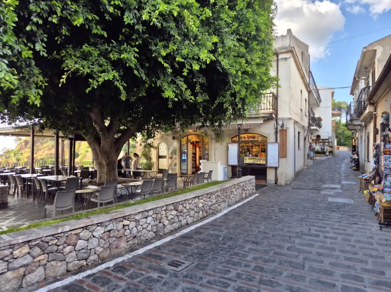 La place Principale du village avec ses ruelles en pierres et ses arbres.