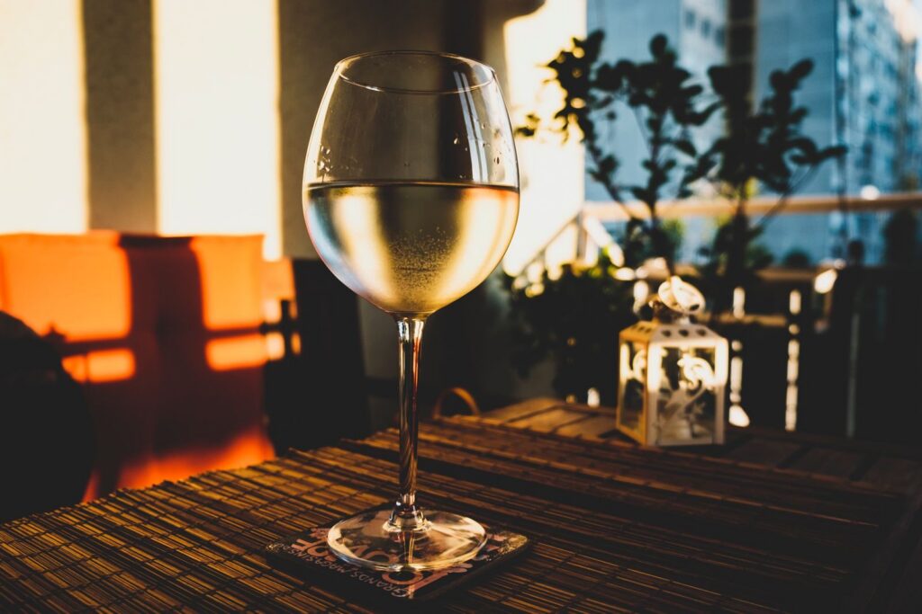 Verre de vin blanc de Tenerife, minéral et désaltérant, servi sur une terrasse au coucher du soleil.