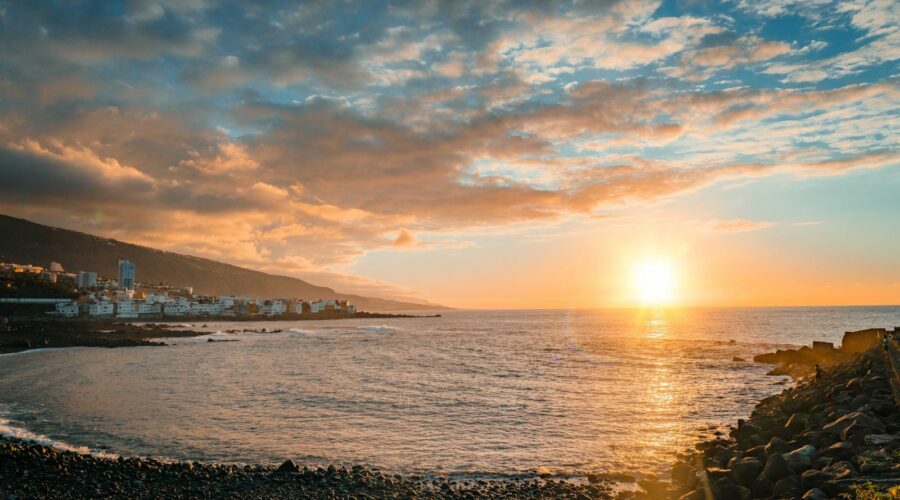 Coucher de soleil ensoleillé sur une plage et la côte de Tenerife aux îles Canaries